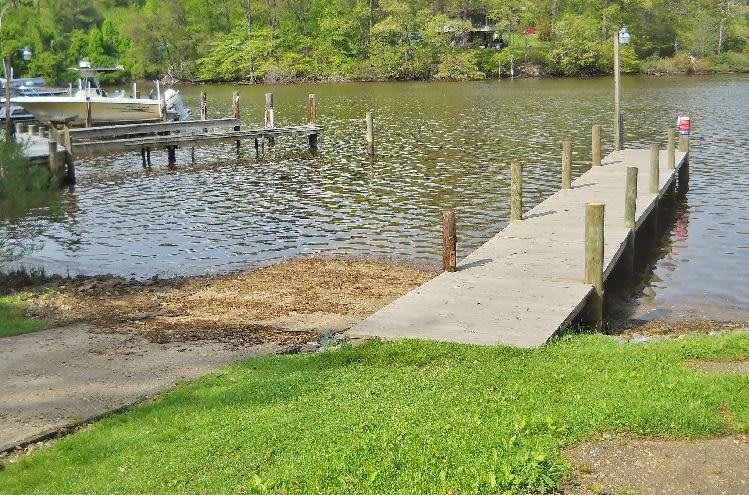A peaceful lakeside scene with a wooden dock extending into the water.