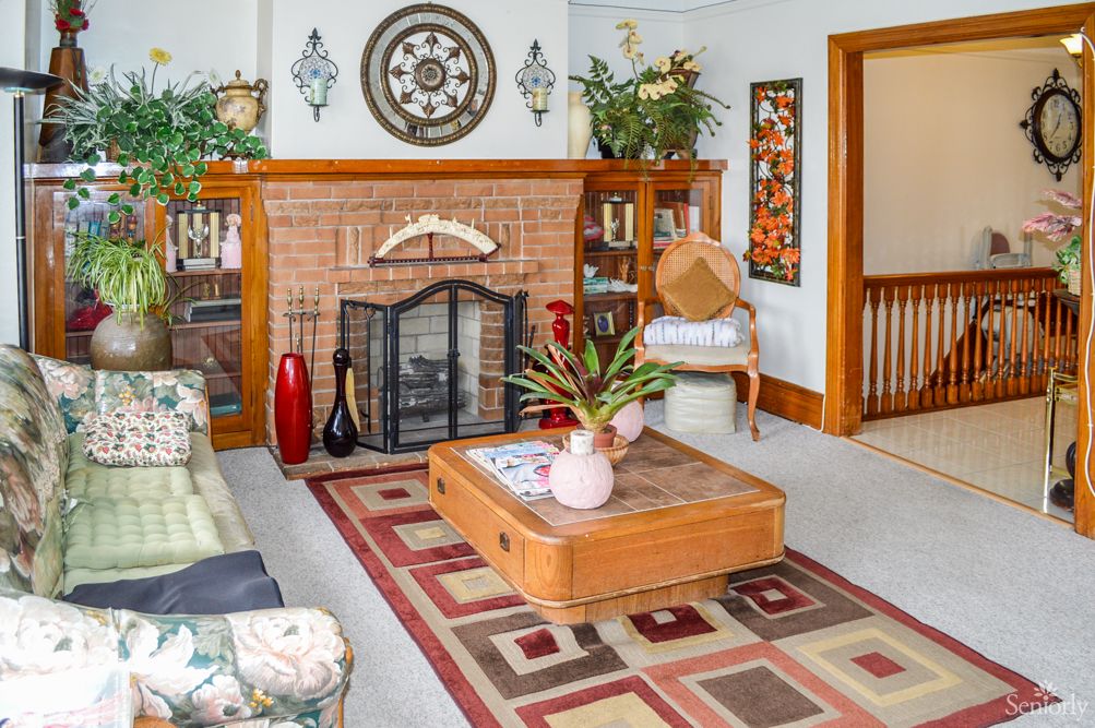 A cozy living room with a brick fireplace, stylish decor, and comfortable furniture.