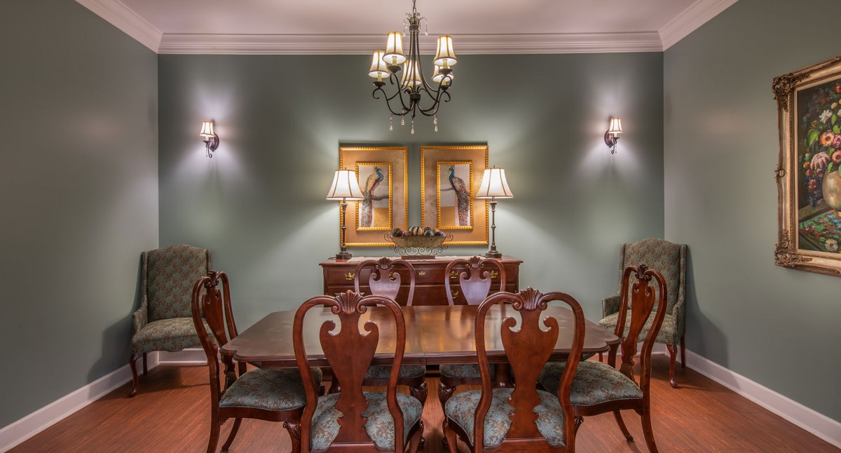 A traditional dining room with elegant wooden furniture and a classic chandelier.