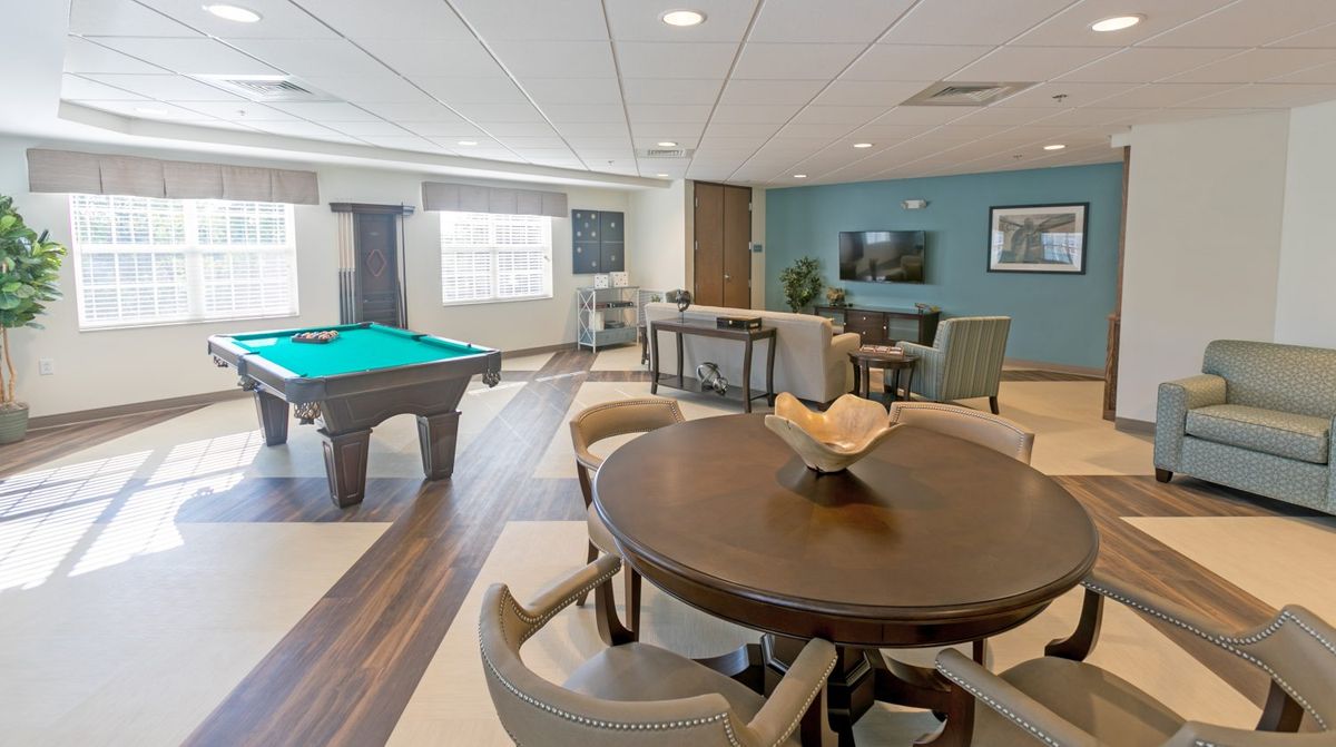 A modern recreation room featuring a pool table and comfortable seating area.