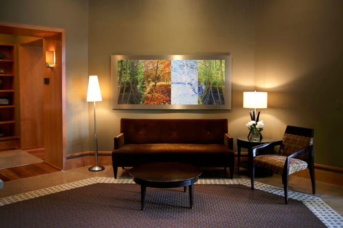 A cozy living room with a sofa, two lamps, and wall artwork.