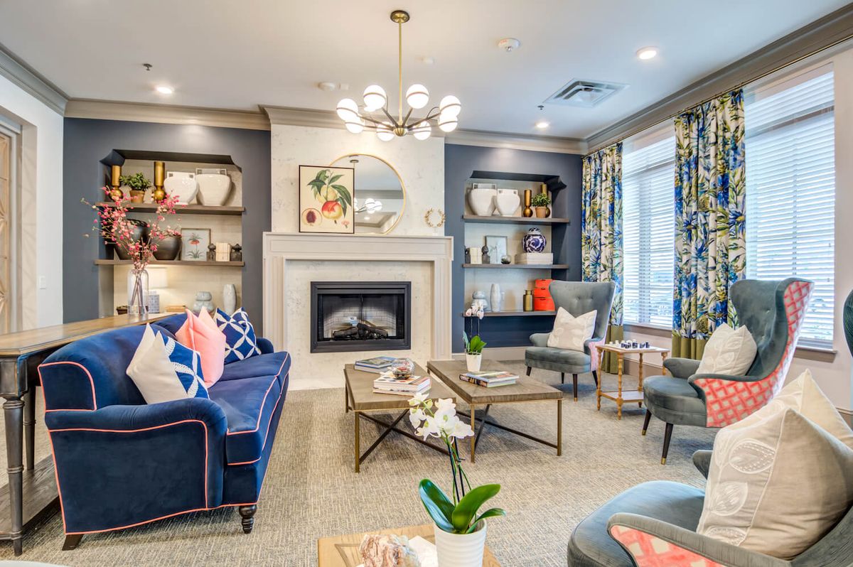 A cozy and elegantly designed living room featuring a fireplace, modern furniture, and decorative shelves.
