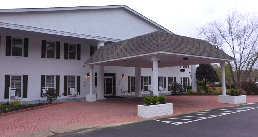 A building entrance with a covered walkway supported by columns.