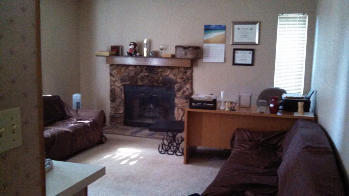 A cozy living room with a stone fireplace and comfortable seating.