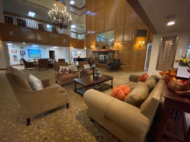 A luxurious hotel lobby with elegant seating, a grand chandelier, and wooden wall paneling.
