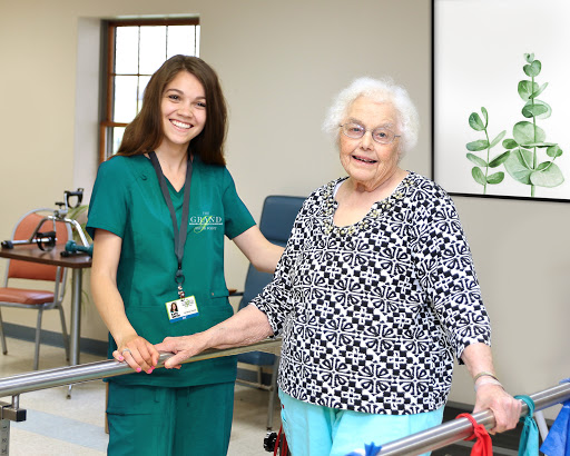 A nurse assisting an elderly patient during a rehabilitation session.