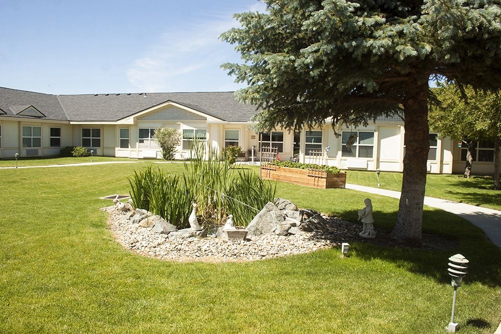 A serene outdoor landscape with a garden and building in the background.