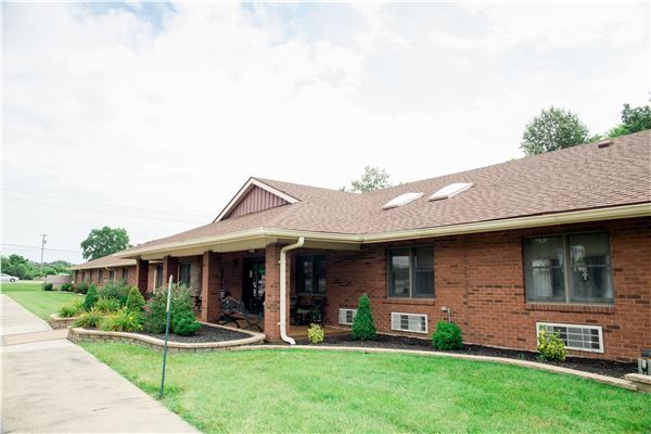 A residential brick house with a well-maintained lawn.