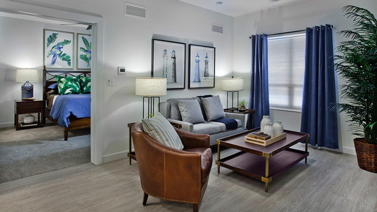 A cozy living room with a sofa, leather armchair, and stylish decor.