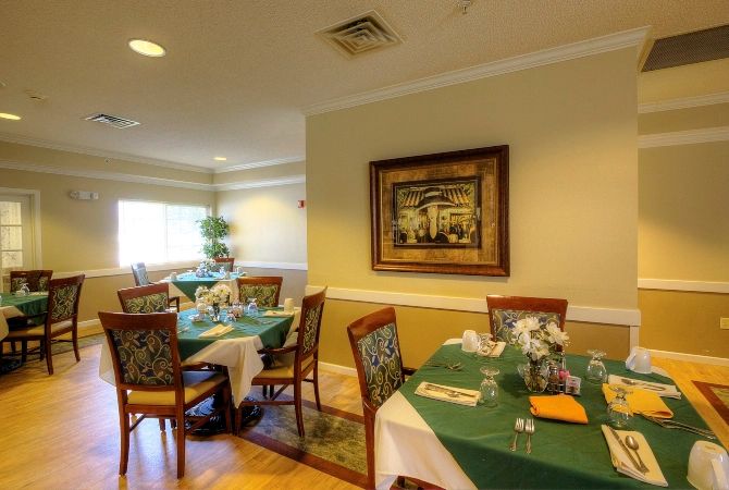 A cozy dining area with neatly arranged tables and chairs, featuring elegant decor.