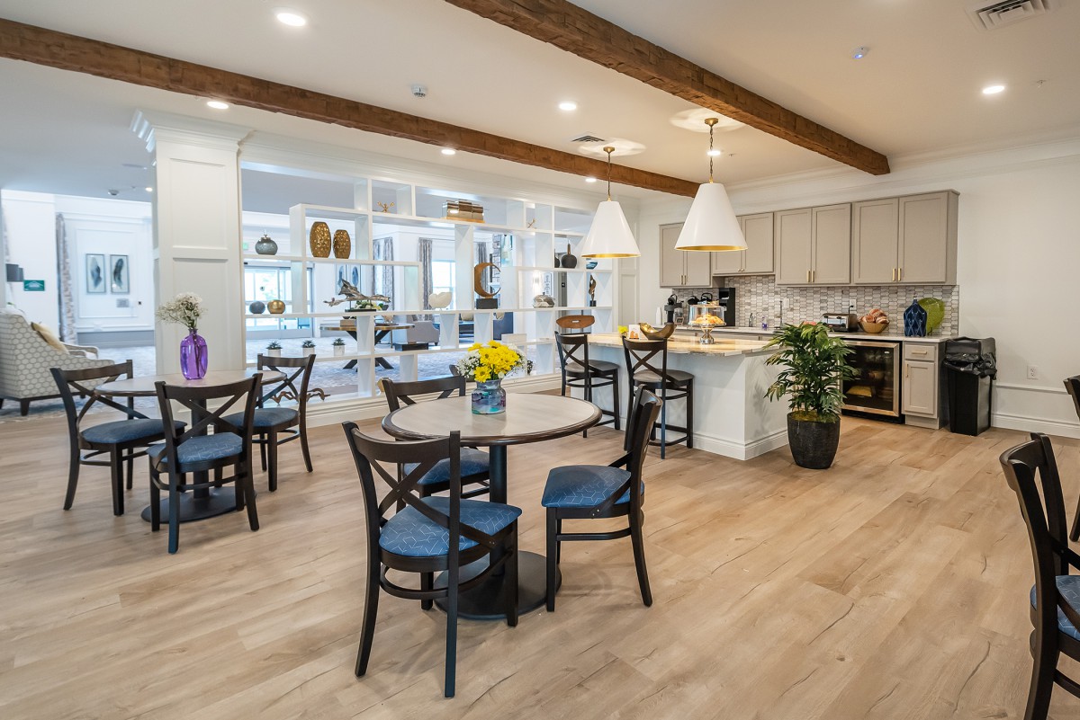 Modern kitchen and dining area with wooden beams and stylish lighting.