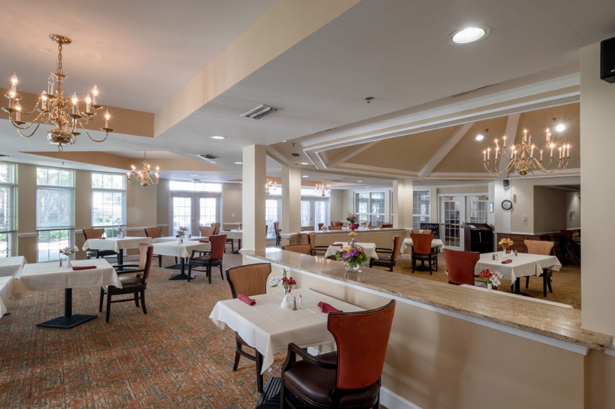 Spacious restaurant interior with elegant dining setup and chandeliers.