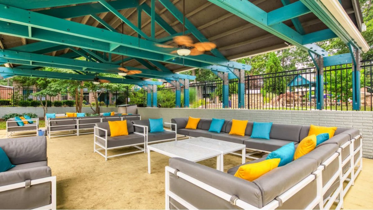 Outdoor lounge area with colorful cushions and modern patio furniture under a canopy.