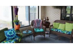 Cozy patio area with wicker chairs, colorful cushions, and decorative elements.