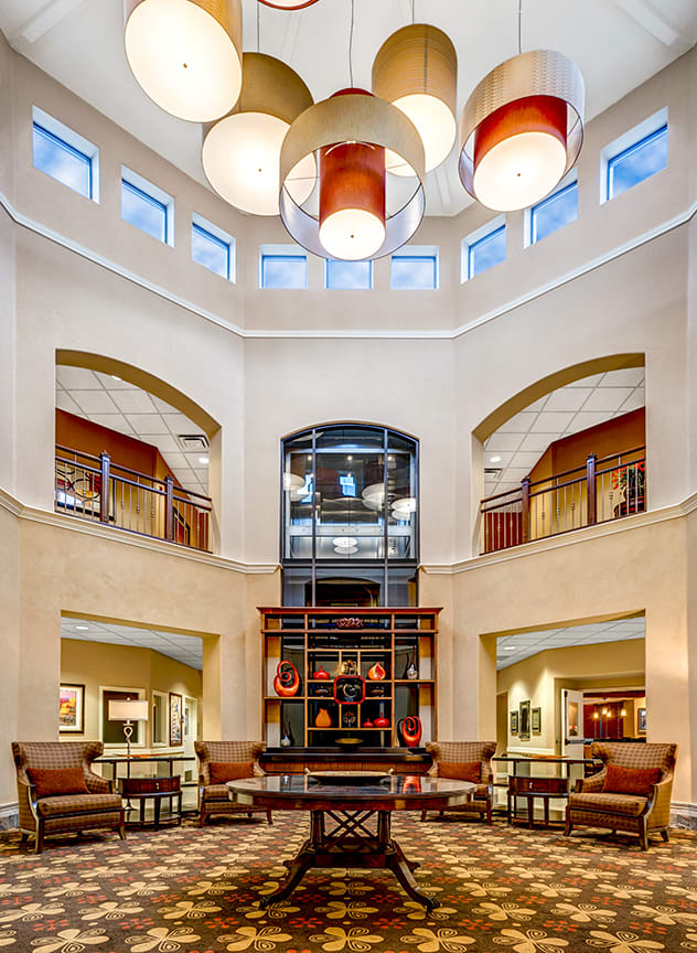 A modern lobby with high ceilings, elegant lighting, and comfortable seating areas.