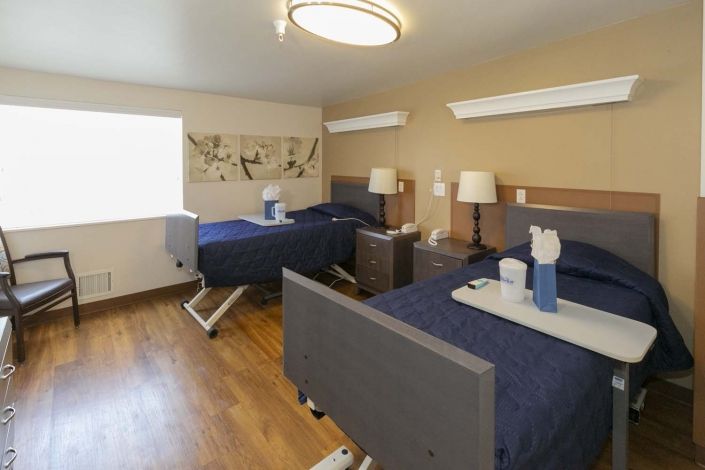 A modern room with two neatly made beds, featuring stylish decor and warm lighting.