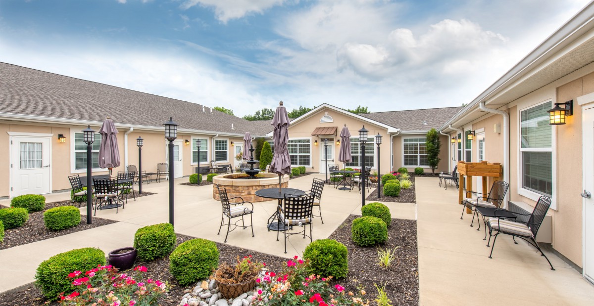 A beautifully landscaped courtyard with outdoor seating and a central fountain, perfect for relaxation.