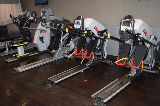 A row of rowing machines in a gym ready for use.