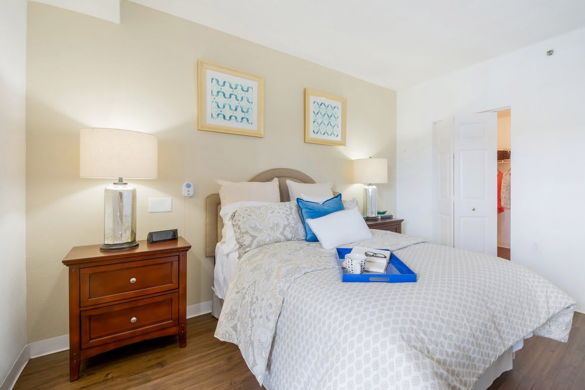 A cozy bedroom with a neatly made bed, bedside tables, and soft lighting.