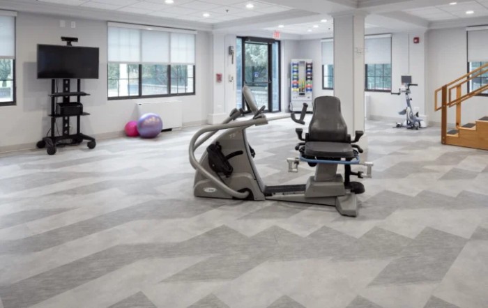 A modern gym space featuring a variety of fitness equipment and bright lighting.