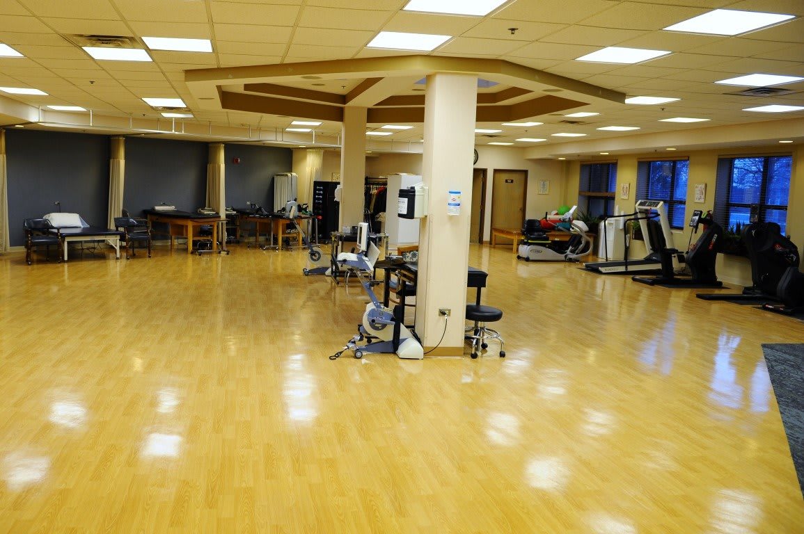 A spacious gym with various exercise equipment and treadmills, ready for workouts.