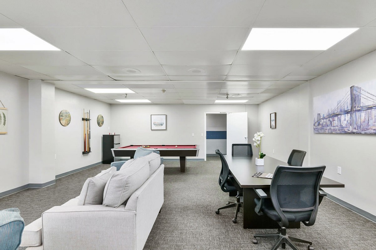 Modern office space with a meeting area and recreational pool table.