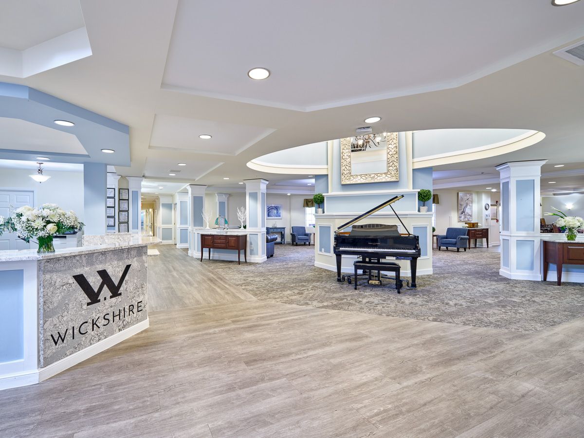 Modern lobby interior with a grand piano and reception desk.