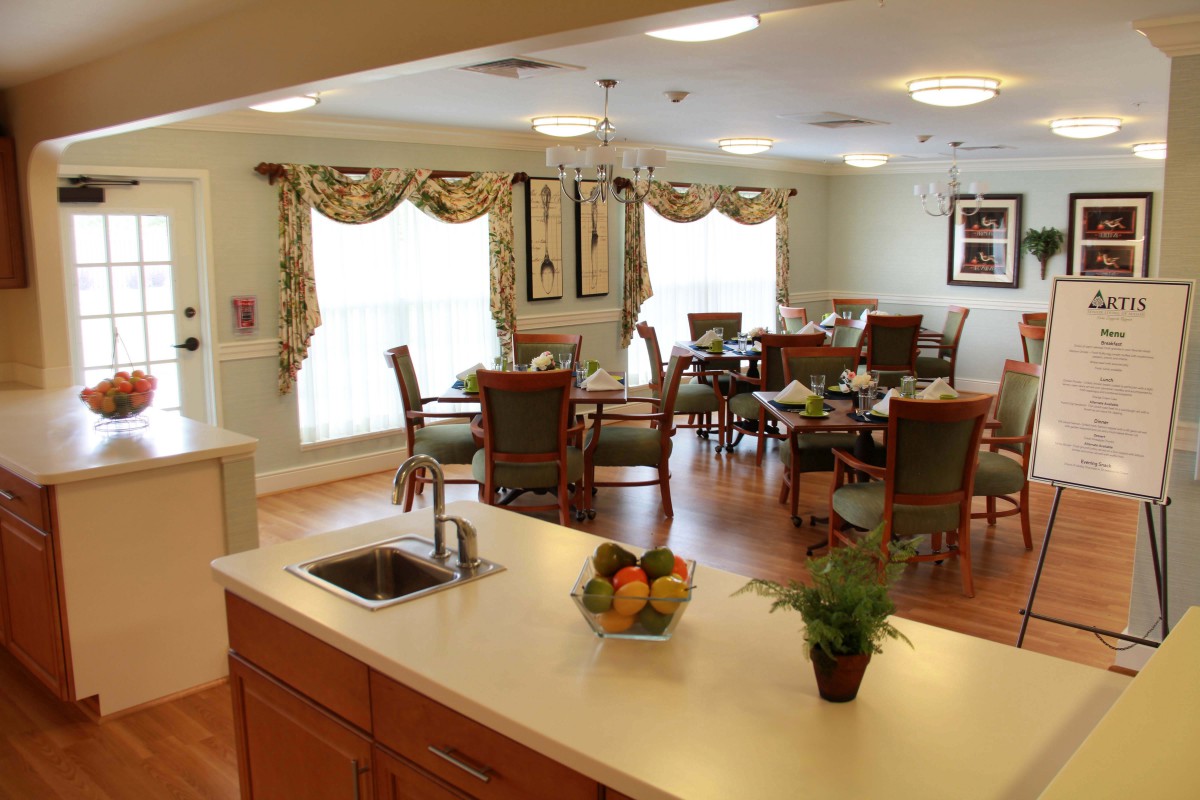 A cozy dining area with a kitchen counter, featuring elegant decor and ample natural light.