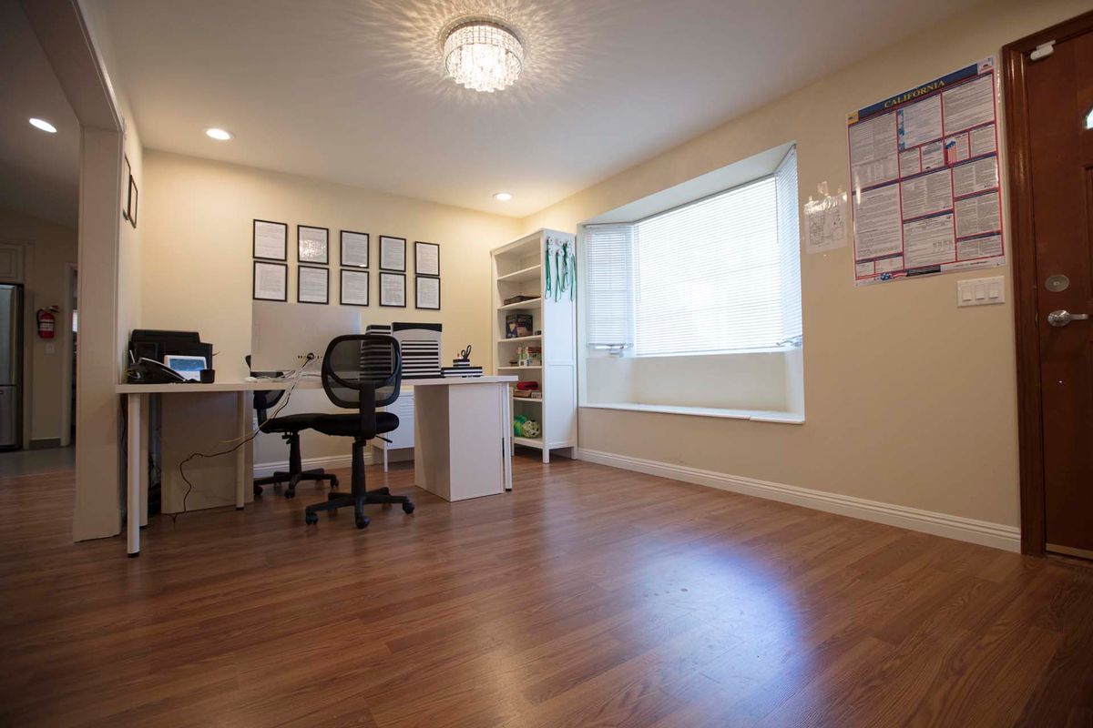 A spacious and organized home office with hardwood floors and ample natural light.