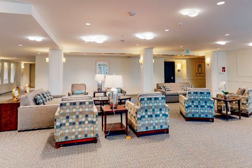 A spacious living room with modern furniture and seating arrangements.