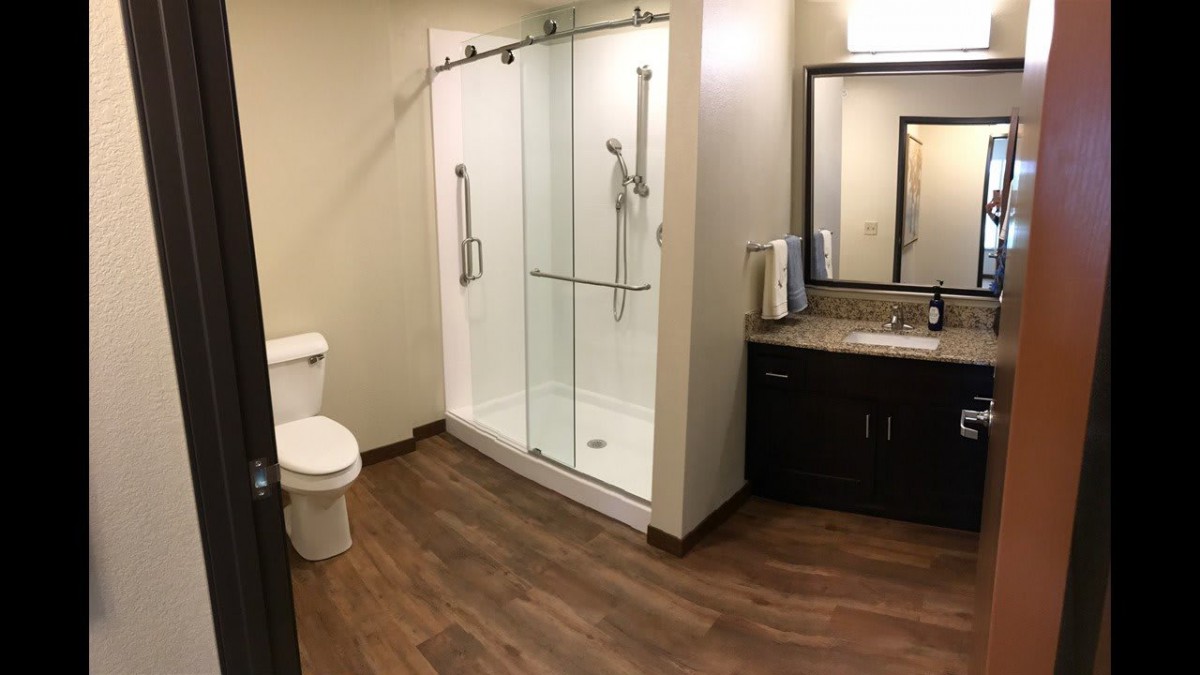 Modern bathroom with a shower, toilet, and sink.
