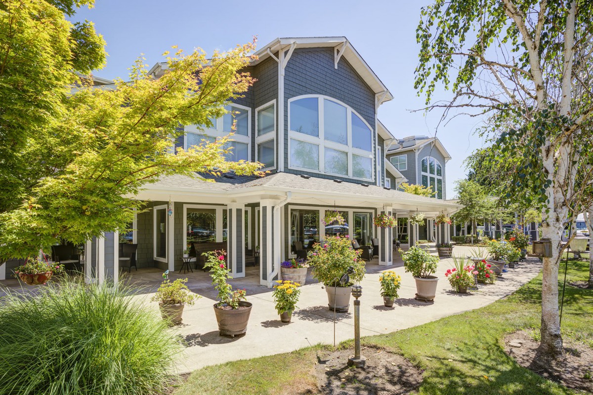 A beautiful two-story house with large windows and a landscaped garden.