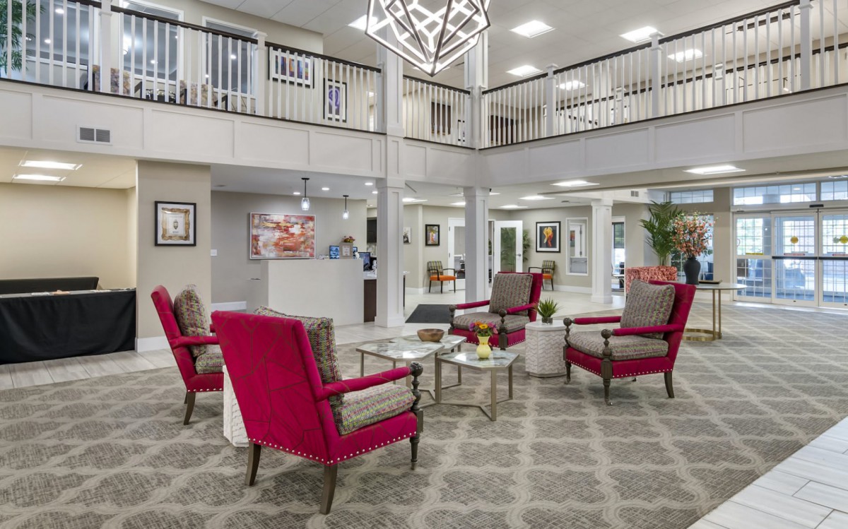 A modern lobby with red chairs and stylish interior design.