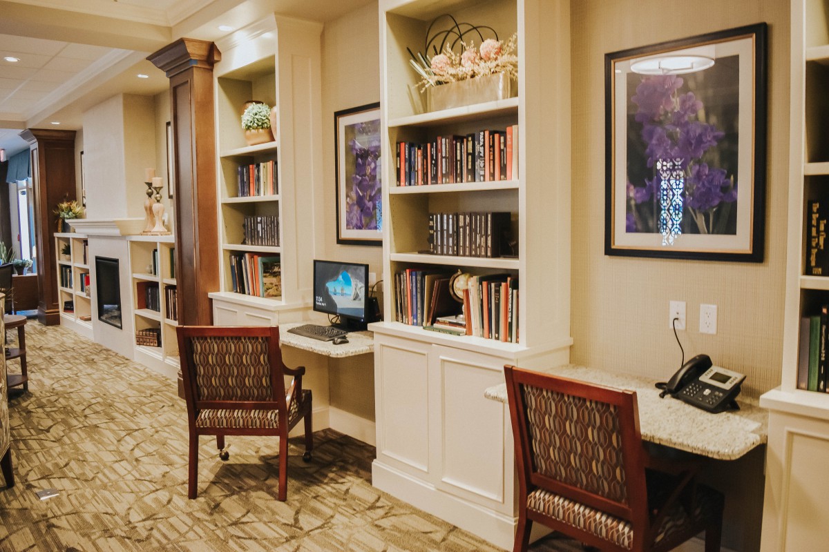A cozy library corner with bookshelves and computer stations.