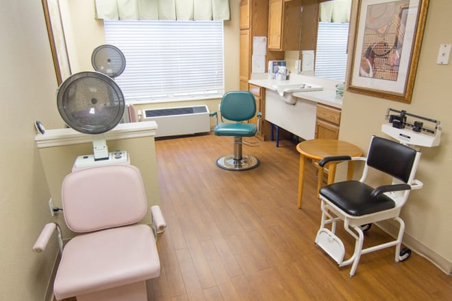 A cozy salon with various seating and a hair dryer station.