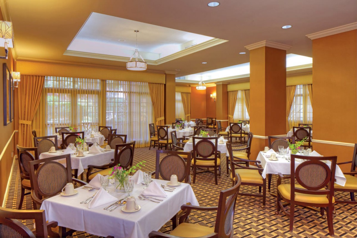 A beautifully set restaurant dining room with elegant decor and neatly arranged tables.