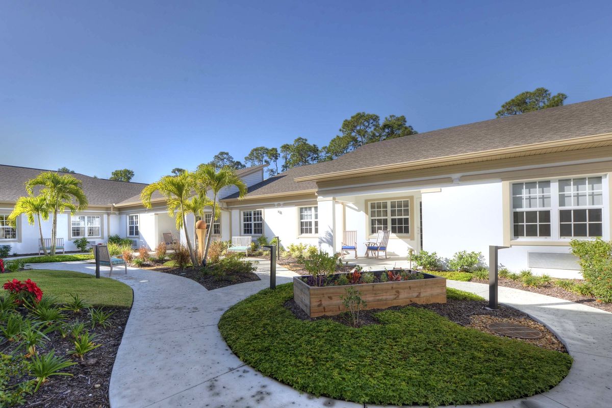 A modern residential complex with well-maintained gardens and a winding pathway.