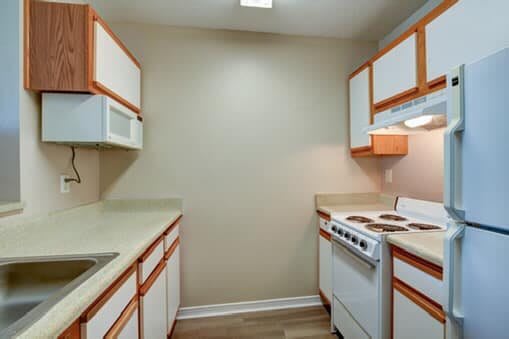 A compact kitchen with white cabinets and modern appliances.