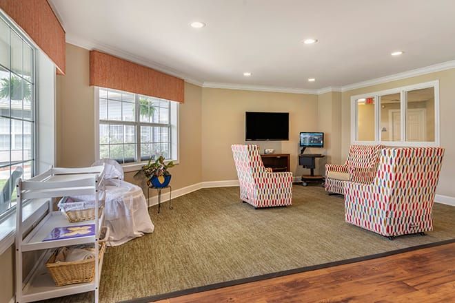 A cozy living room with patterned chairs and a television.
