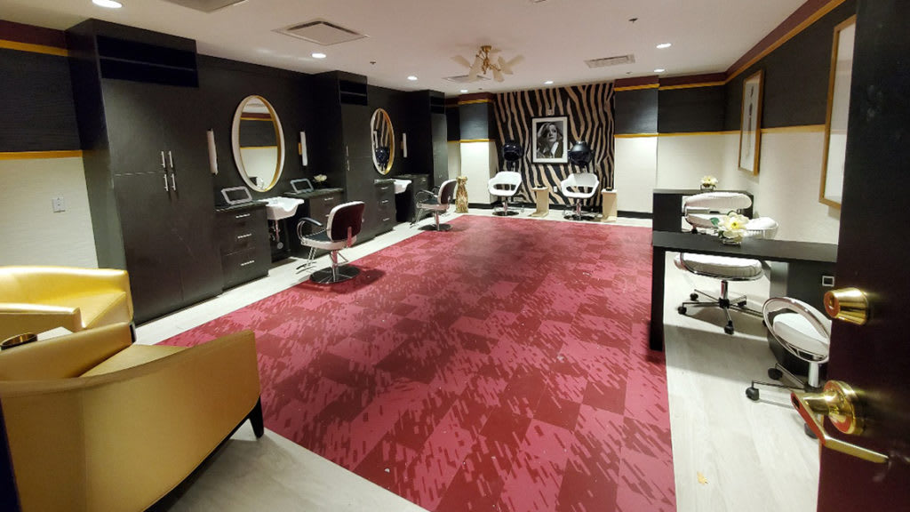 A stylish salon interior with mirrors and chairs on a red carpet.