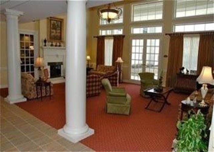 A spacious living room with large windows, a fireplace, and comfortable seating.