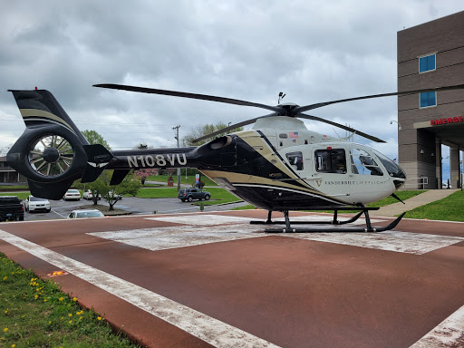 A sleek black and gold helicopter rests on a landing pad, ready for its next flight.