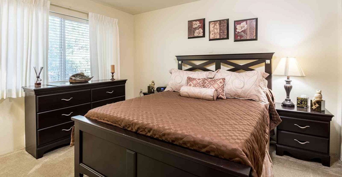A cozy bedroom with a neatly made bed and stylish decor.