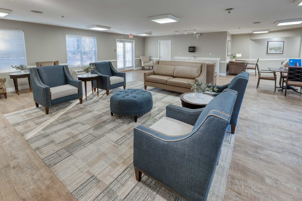A modern living room with a cozy seating area, featuring sofas, chairs, and coffee tables.
