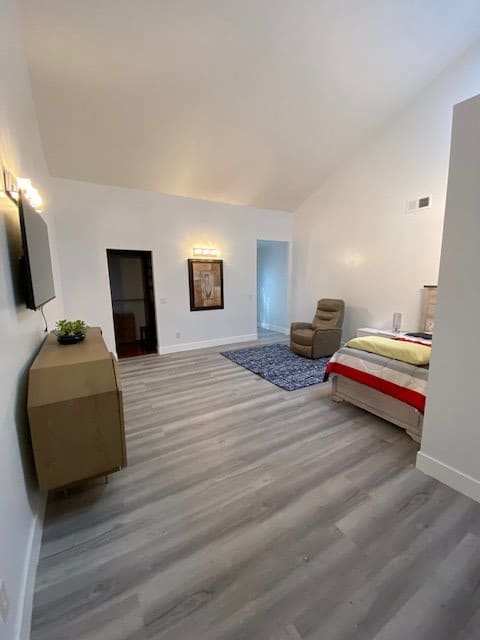 A modern minimalist bedroom with sleek furnishings and ample space.