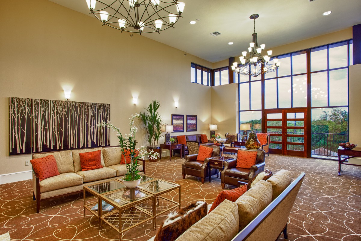 A spacious and elegantly designed lobby with comfortable seating, chandeliers, and modern artwork.
