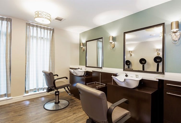 A modern hair salon interior with styling chairs and wash basins.