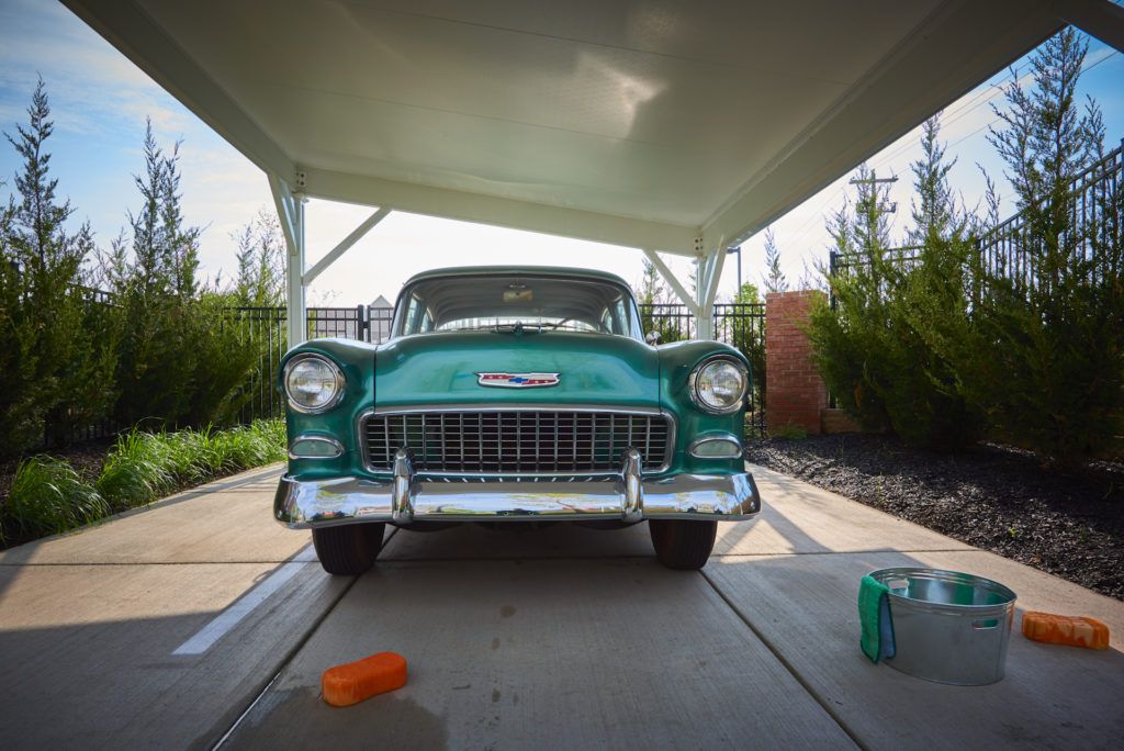 A classic teal Chevrolet from the 1950s parked under a canopy, ready for a wash.