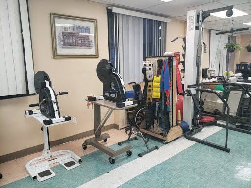 A physical therapy room equipped with various exercise machines and rehabilitation tools.