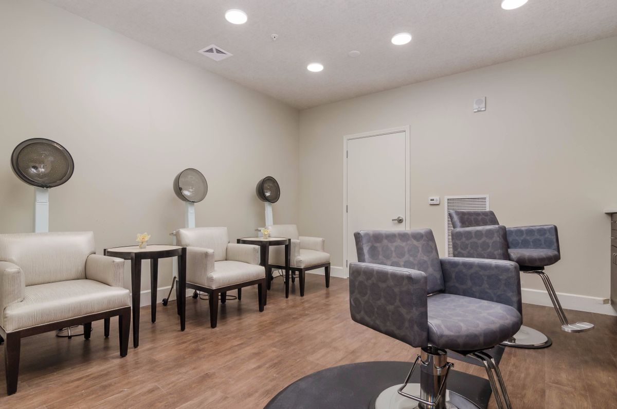 A modern hair salon interior with chairs and mirrors.
